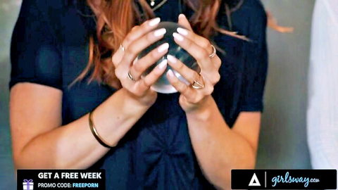 Jayden Cole in seductive psychic pose holding crystal ball, redhead beauty