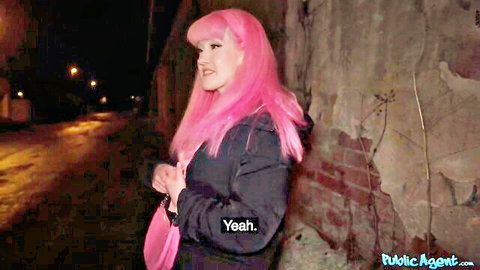Evie Rees with pink hair in black hoodie, smiling in dark alley tease