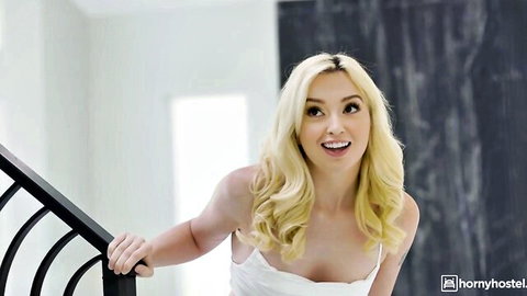 Lexi Lore blonde smiling seductively in low-cut white top