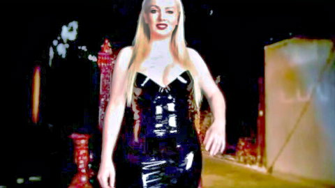 Blonde dominatrix Lexi Sindel in shiny black latex dress, seductive pose for hypno fetish video