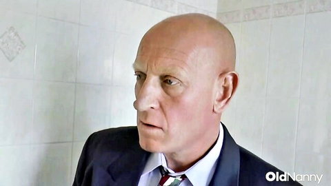 Sam Bourne in suit stares intensely in Maggie Moon British MILF hardcore scene