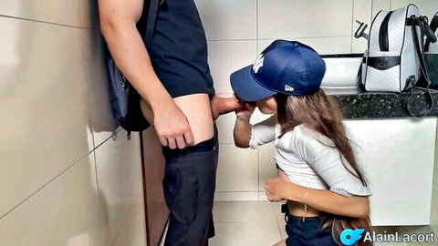 Asian college girl in uniform kneels for blowjob on friend in bathroom