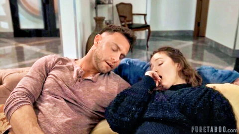 Brunette woman seduces sleeping muscular man on sofa in intimate foreplay
