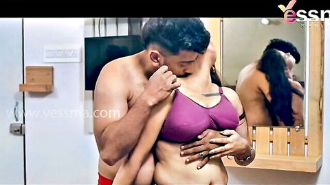 Muscular Indian man gropes busty South Asian MILF's tits in purple bra while kissing her neck in steamy bathroom mirror