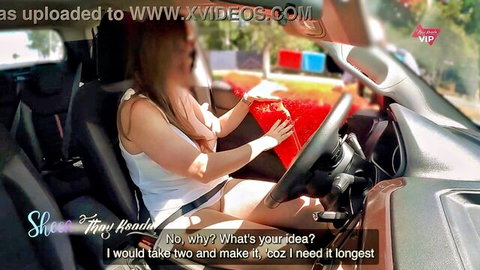 Busty woman in car gripping thick red dildo with big tits cleavage spilling out