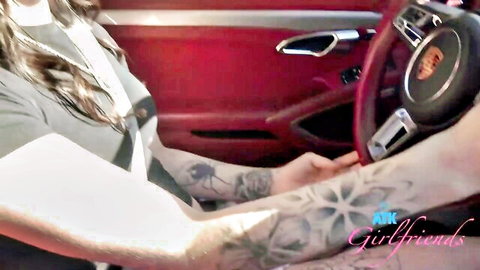 Tattooed woman driving red Porsche in seductive girlfriend tease