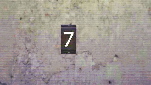 Cracked beige brick wall with black rectangular sign displaying white number 7