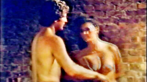 Vintage 1984 nude couple embracing intimately against brick wall in Snake Eyes porno