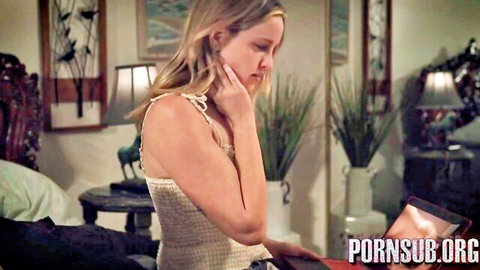 Blonde stepmom in tank top looks concerned while watching porn on laptop