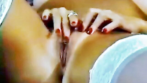 Close-up of mature woman's tan-lined pussy spread by red-nailed hands in white lingerie