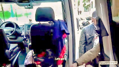 Ebony man in jacket chats up woman inside bus door