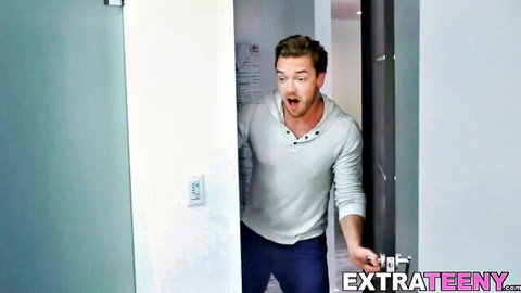 Surprised young guy in henley shirt opens door in modern bathroom