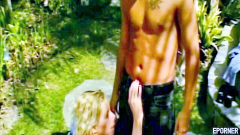 Vintage porn thumbnail: blonde woman in white dress touching muscular tattooed man's crotch outdoors