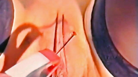 Close-up vaginal piercing with needles and tools in explicit fetish scene