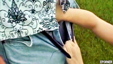 Fair-skinned woman in lace dress pulls out big erect cock from man's jeans outdoors