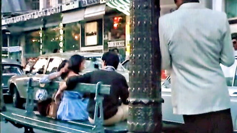 Clothed Asian couple embracing intimately on urban bench at night under neon lights
