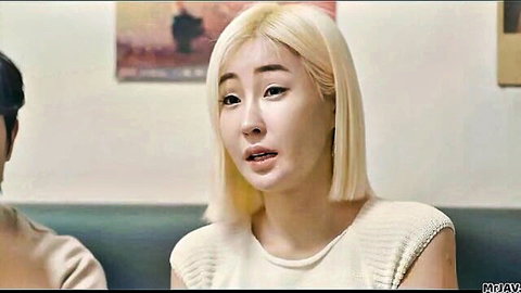 Blonde Asian woman in off-shoulder top sitting with man, softcore studio chat