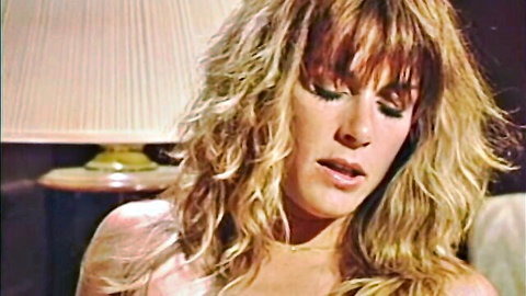 Vintage blonde bombshell with big wavy hair moaning in ecstasy closeup