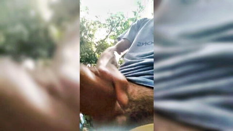 Blurry thumbnail of man in shirt holding crotch outdoors, pissing tease