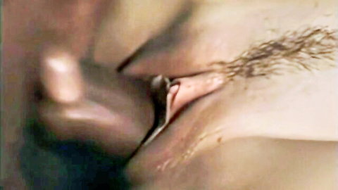 Close-up of hairy pink pussy spread wide open by fingers exposing wet vulva