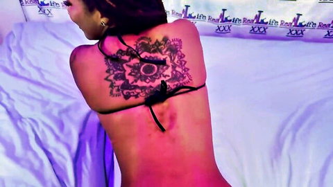 Curvy brunette with mandala back tattoo teases big ass in black bikini thong on bed
