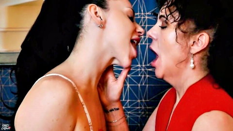Two brunettes passionately French kissing with tongues out in steamy lesbian makeout