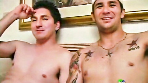 Two shirtless muscular tattooed men smiling and posing together shirtless