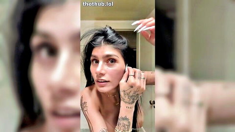 Mia Khalifa topless close-up with tattoos and long dark hair