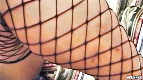 Closeup of sexy big ass in sheer black fishnet stockings teasing on red couch