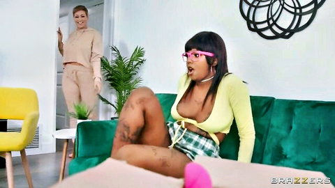 Daizy Cooper legs spread in yellow crop top, Ryan Keely watches in sweats