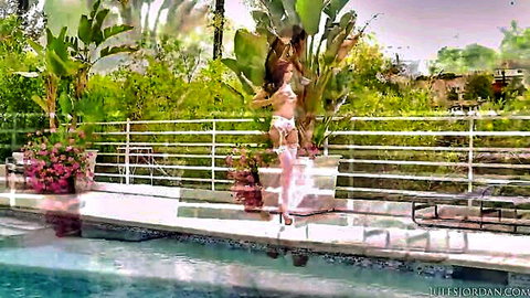 Sexy brunette babe in white thong bikini and stockings posing seductively by the pool