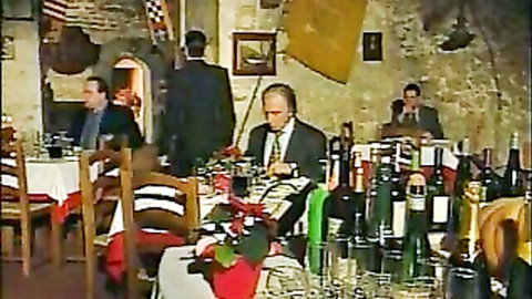 Vintage restaurant dinner scene with suited men and women in classic adult movie