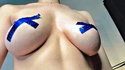 Busty webcam babe teases with blue duct tape X over her huge bare tits