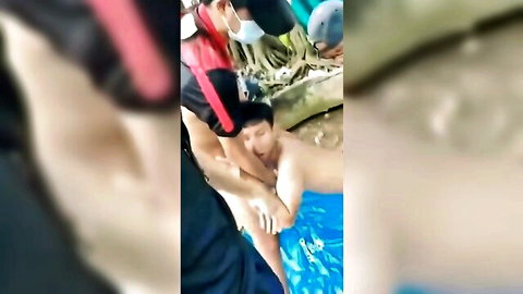 Asian men grope naked dude in public outdoor pool orgy