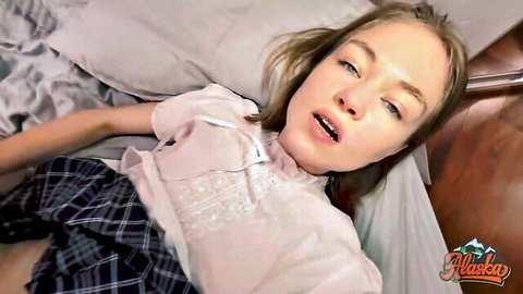 Blonde teen in schoolgirl outfit lying seductively on bed, POV tease