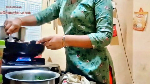 Sexy Indian MILF cooking in kitchen wearing tight green floral dress big tits