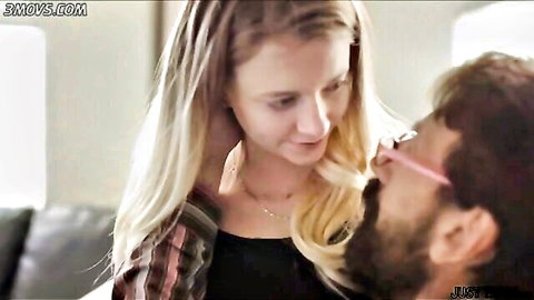 Blonde woman in plaid shirt embraced intimately by bearded man with glasses