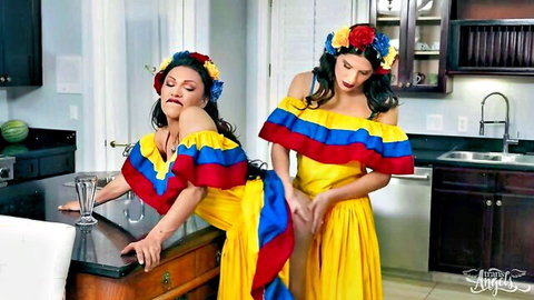 Two sexy Latinas in tight Colombian flag dresses teasing seductively over kitchen counter