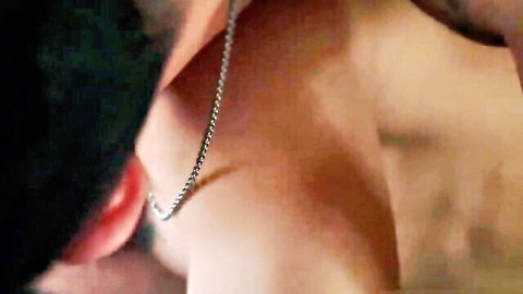 Close-up of muscular tattooed man's neck with silver chain necklace in gay porn scene