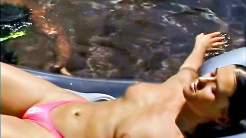 Topless brunette babe with bare tits lounging in bubbling jacuzzi wearing pink thong