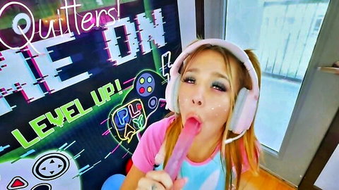 Cute gamer girl with pigtails sucking pink lollipop in headset
