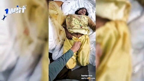 Indian MILF in yellow saree lying on bed, hand touching waist