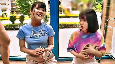 Two smiling Asian JAV actresses in casual tops, holding cash in sunny room