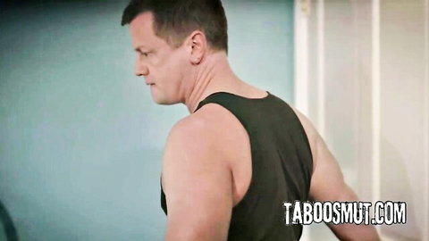 Muscular stepdad in tight black tank top showing ripped arms in taboo video