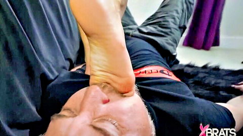 Naomi Swann dominates man with bare foot on face in fetish scene