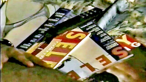 Hand holding stack of vintage sexy magazines featuring lingerie models on covers