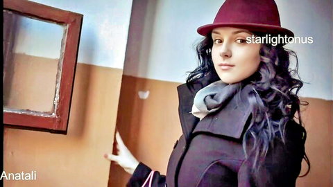 Sexy brunette in red hat and coat posing seductively against old wall