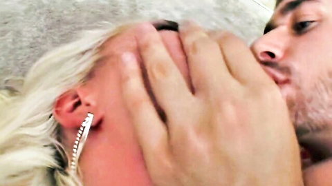 Bearded man roughly hand-gags and kisses terrified blonde woman's face in intense rough sex.