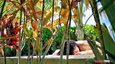 Topless brunette with big tits sideboob lying face down on outdoor table in tropical garden