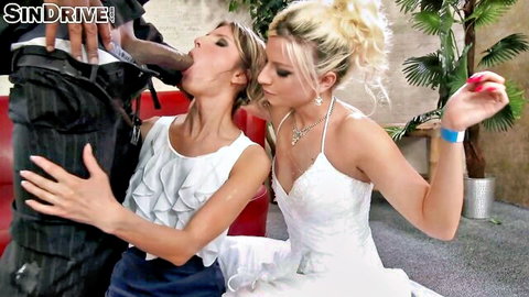 Blonde and brunette brides in white dresses giving blowjob to suited man